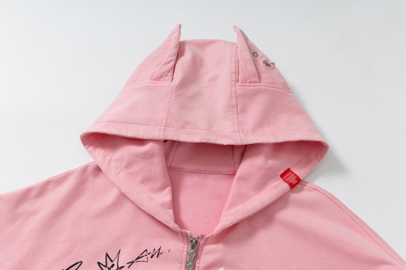 Close-up of pink hoodie hood with pointed ears and snap details