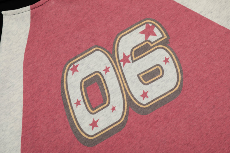 Close-up of pink front panel on colorblock hoodie with large 06 varsity graphic