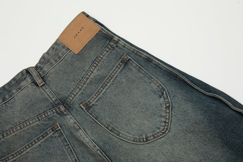 Close-up of back waistband with tan JEANS patch on faded blue denim