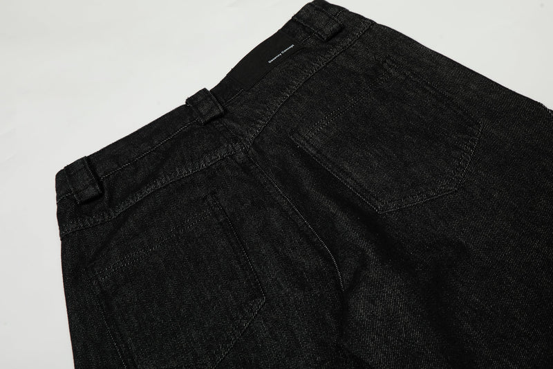 Back waistband of black wide-leg jeans with brand patch and structured seam details
