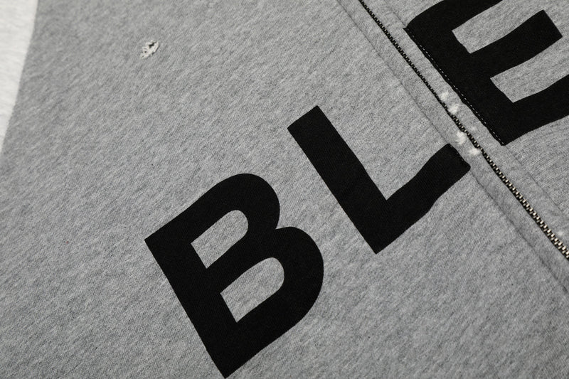 Close-up of bold black BLEG lettering across heather gray hoodie front