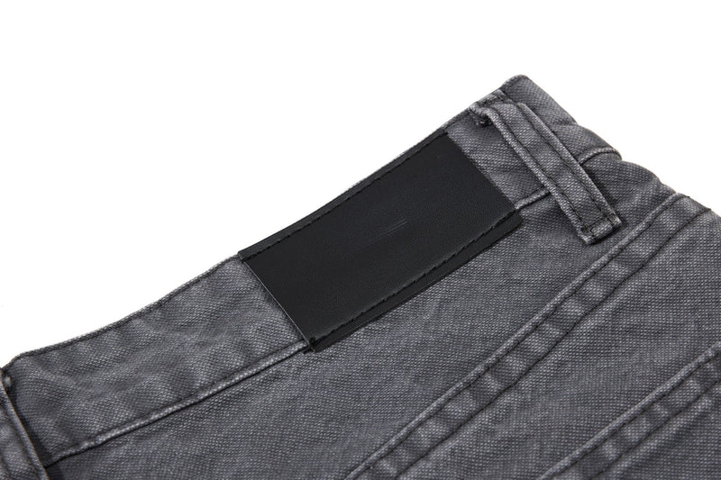 Close-up of charcoal denim back waistband with black patch detail