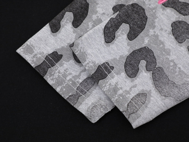 Close-up of gray leopard-print sleeve cuff with double stitching on black tee