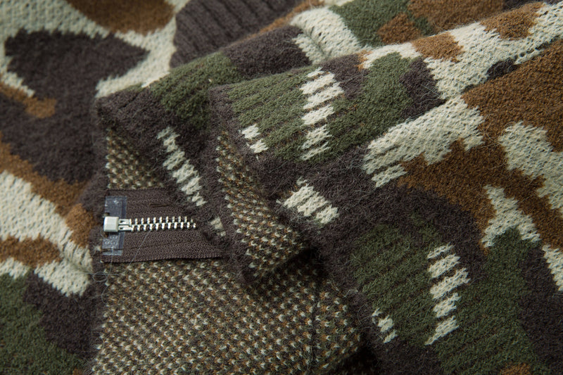 Close-up of the front pocket zipper and knit texture on a camouflage hoodie