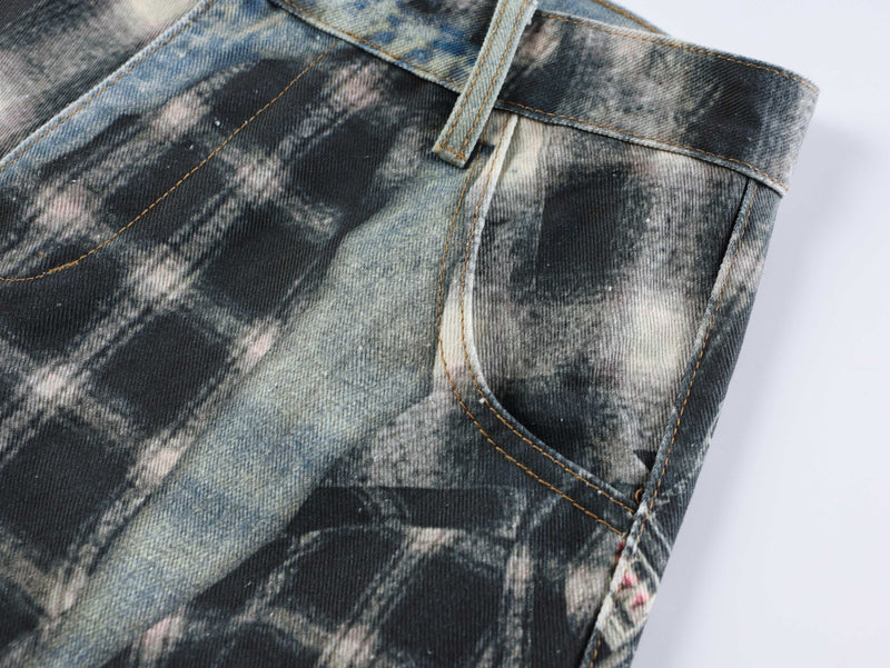 Back pocket detail on patchwork jeans with faded black-and-gray plaid denim