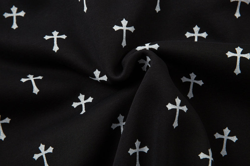 Close-up of black jacket fabric folds with white cross print