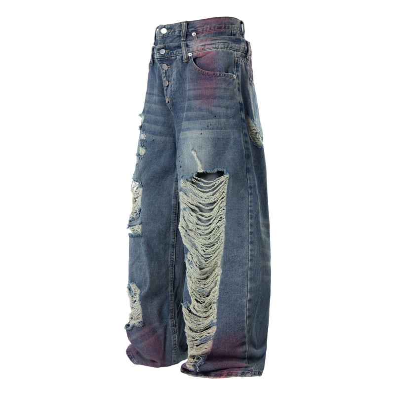 Front angled view of wide-leg jeans with button fly, heavy rips, and faded blue-purple wash