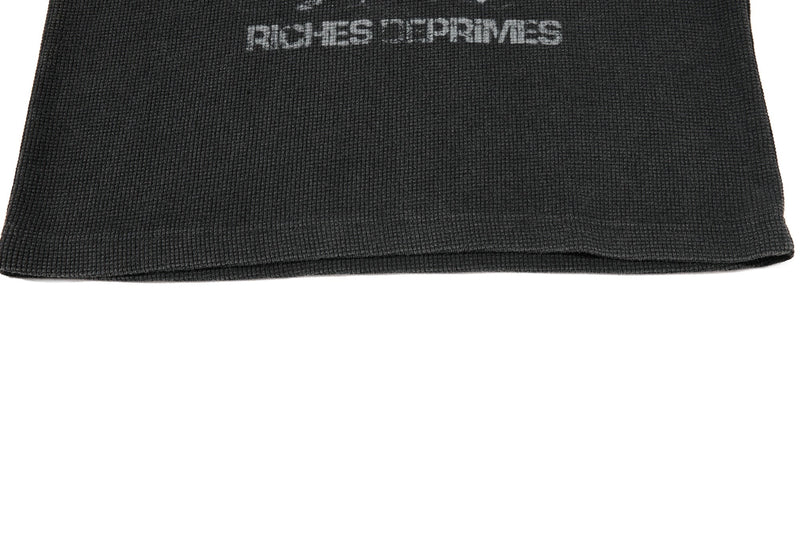 Black waffle knit T-shirt hem with faded Riches Déprimés graphic text on the chest