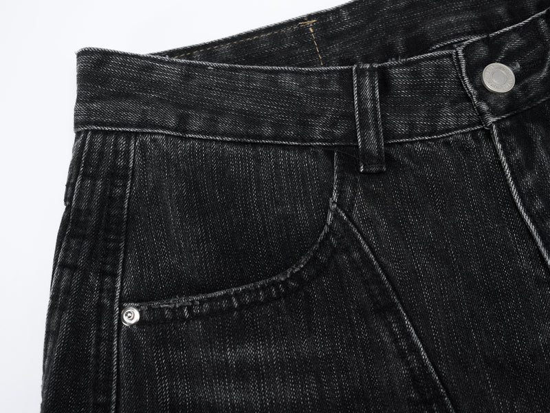 Close-up of black denim waistband and front pocket with button and belt loop