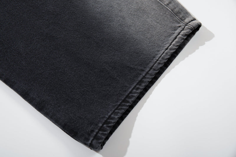 Close-up of the hem on washed black wide-leg jeans