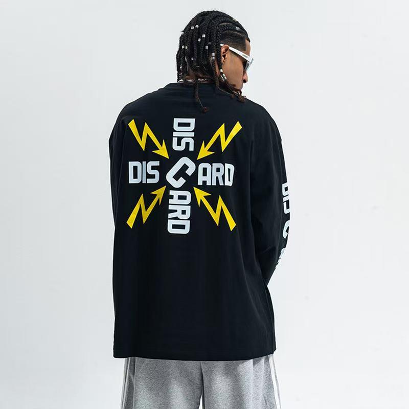 Man wearing black long sleeve tee with DISCARD cross graphic and yellow lightning bolt prints on the back