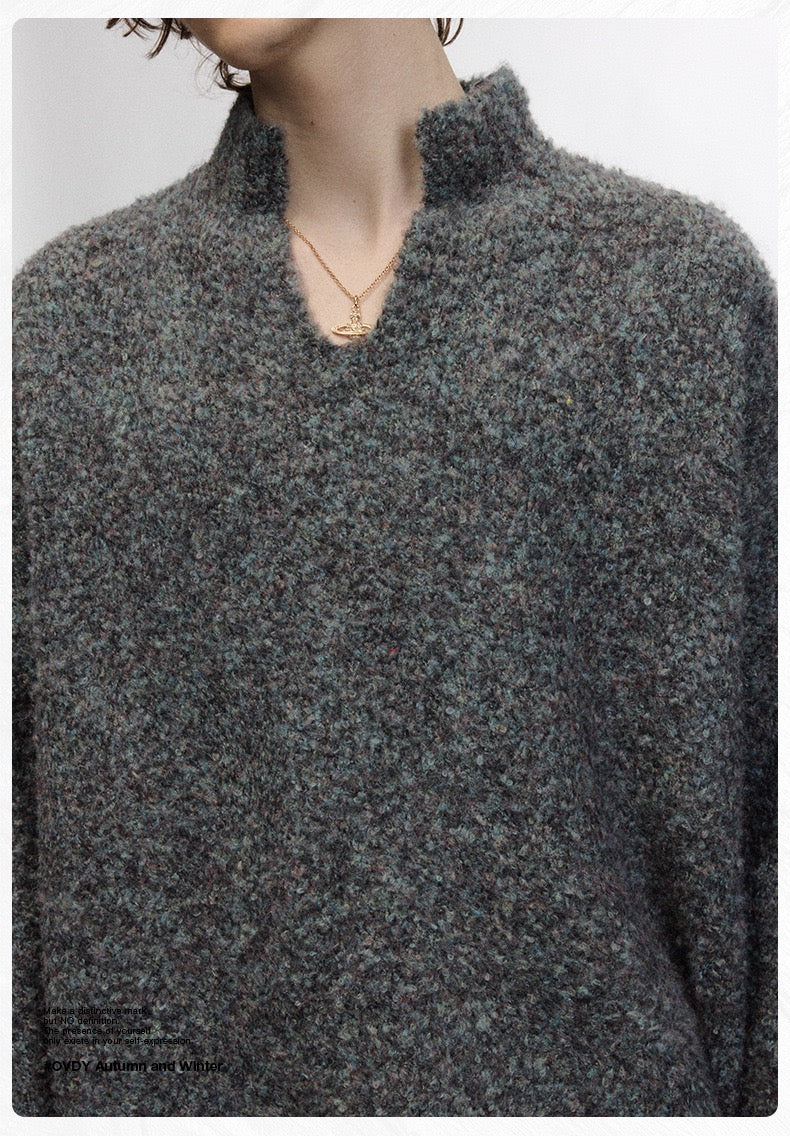 Close-up of dark boucle knit sweater showing half-zip stand collar and fuzzy texture
