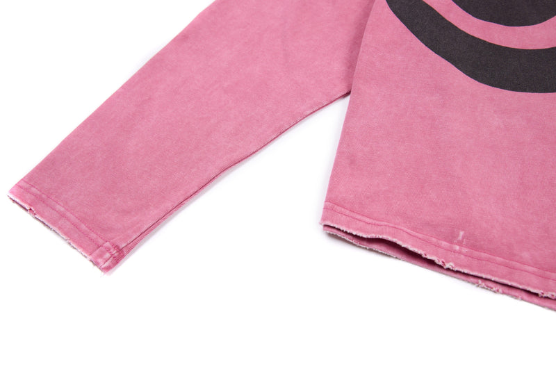 Close-up of pink sleeve and lower front hem on cropped long sleeve tee