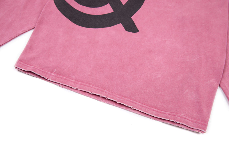 Front hem close-up of pink graphic cropped tee with raw-edged bottom seam