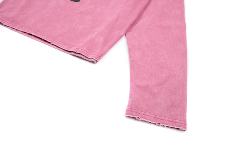 Close-up of pink cuff and cropped hem on long sleeve tee with raw edge detail