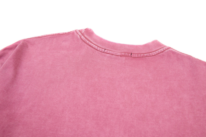 Close-up of pink tee back neckline with ribbed crew neck and stitched seam