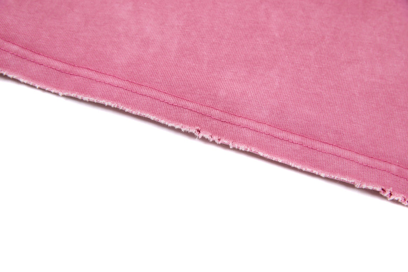 Close-up of pink cropped hem showing double stitching and frayed edge