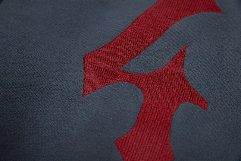Close-up of red gothic print on washed charcoal hoodie fabric
