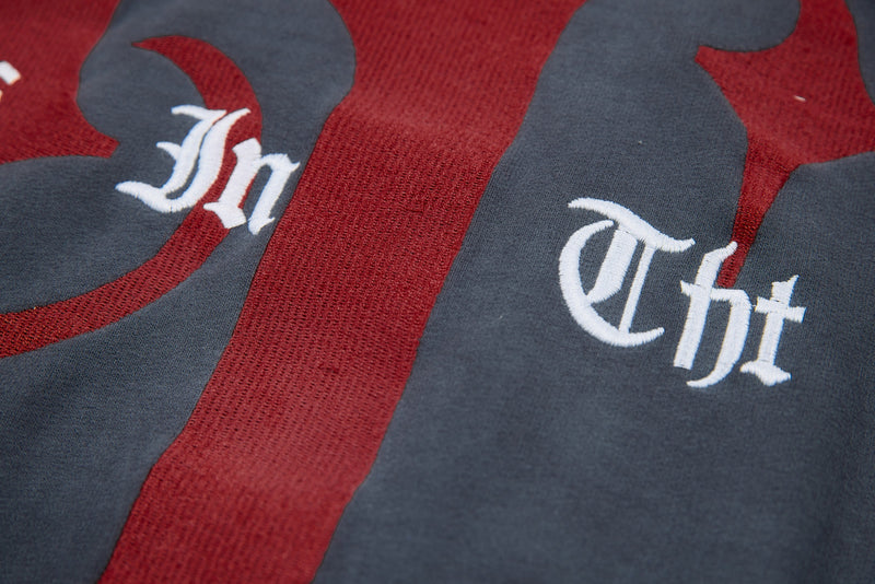 Back graphic close-up showing white gothic lettering over red print on charcoal hoodie
