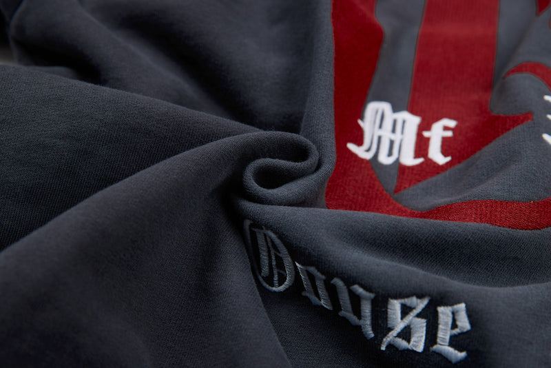 Close-up of red and white gothic text on charcoal hoodie fabric folds