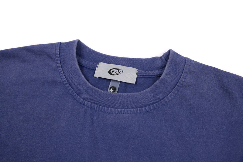 Close-up of ribbed crew neckline and neck label on blue cropped long sleeve tee
