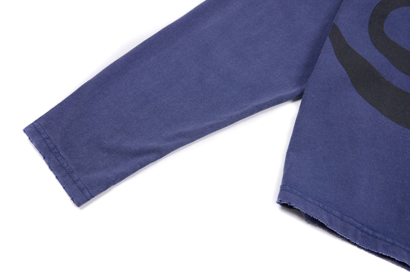 Sleeve close-up of blue long sleeve tee with graphic at the shoulder
