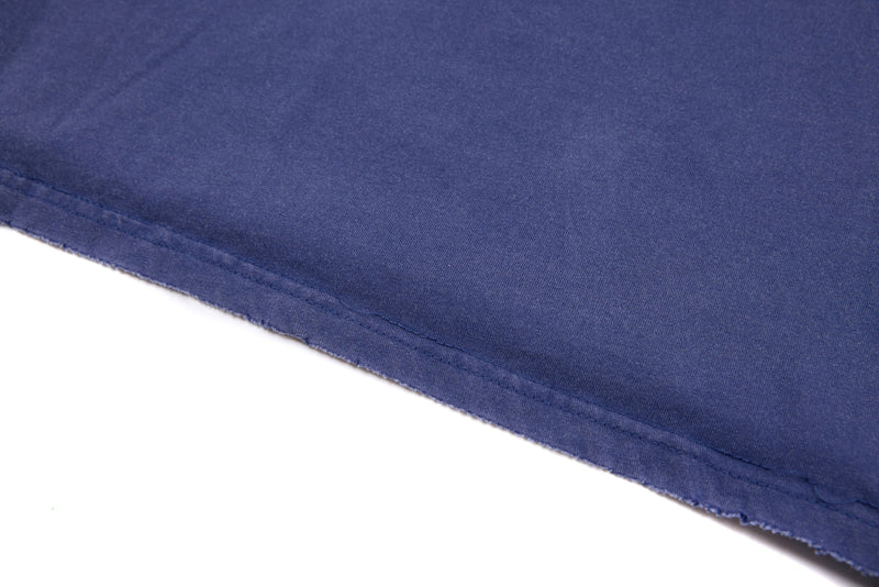 Bottom hem close-up of blue cropped tee with raw edge detailing
