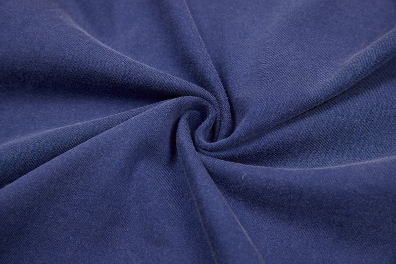 Twisted close-up of blue tee fabric showing soft heavyweight cotton texture