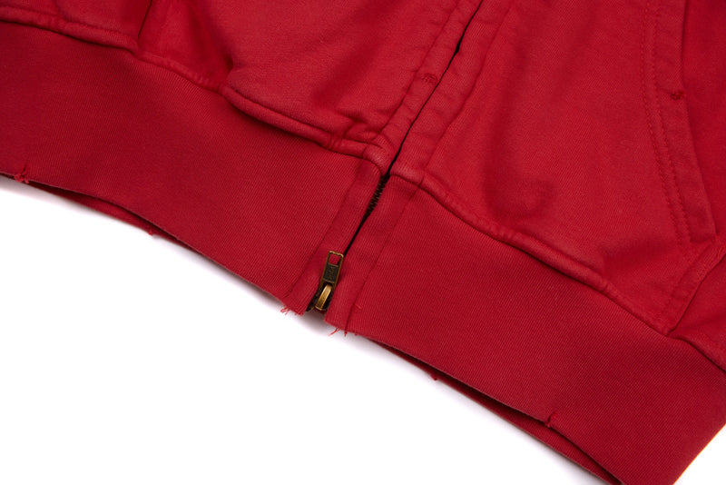 Close-up of red hoodie hem and gold zipper at the bottom front