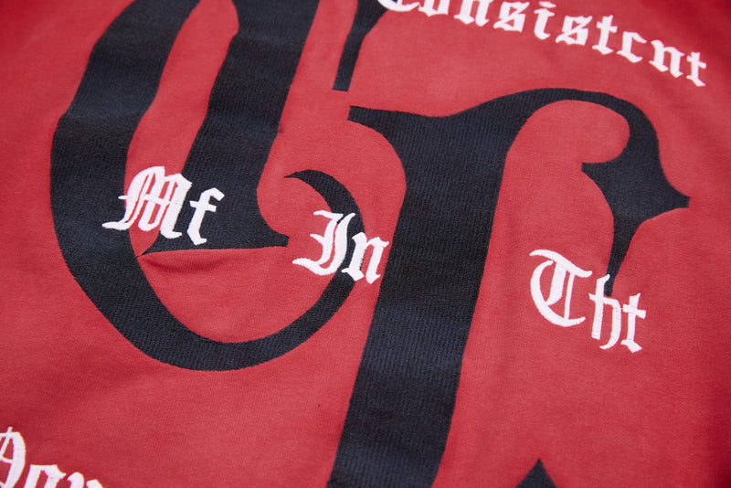 Close-up of red hoodie chest graphic with black gothic letters and white text