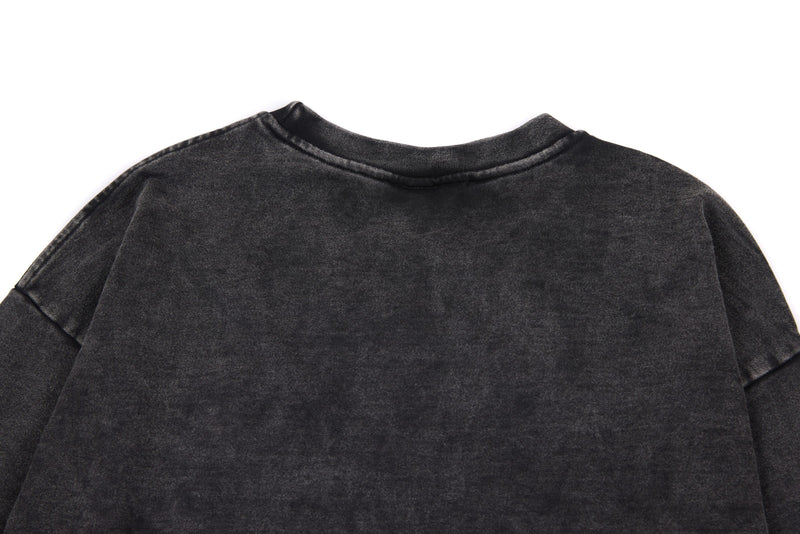 Back yoke close-up of black washed long sleeve tee with faded vintage finish