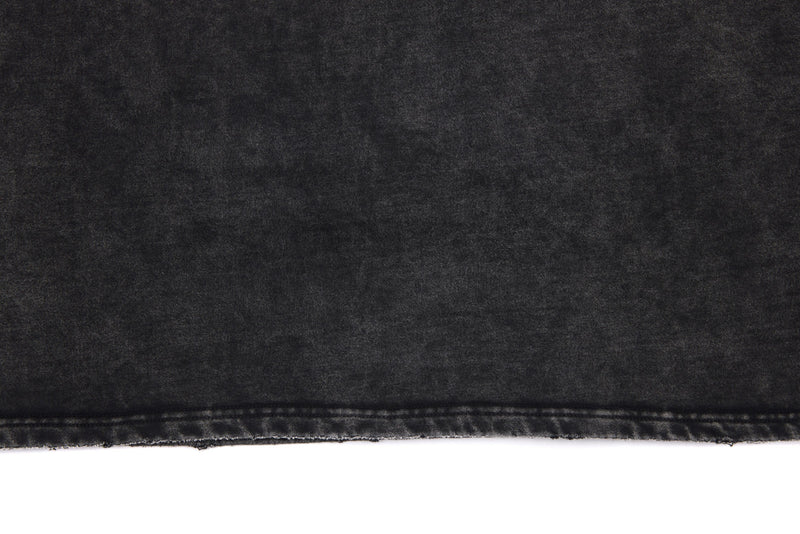 Close-up of black washed tee back hem with raw edge and faded finish