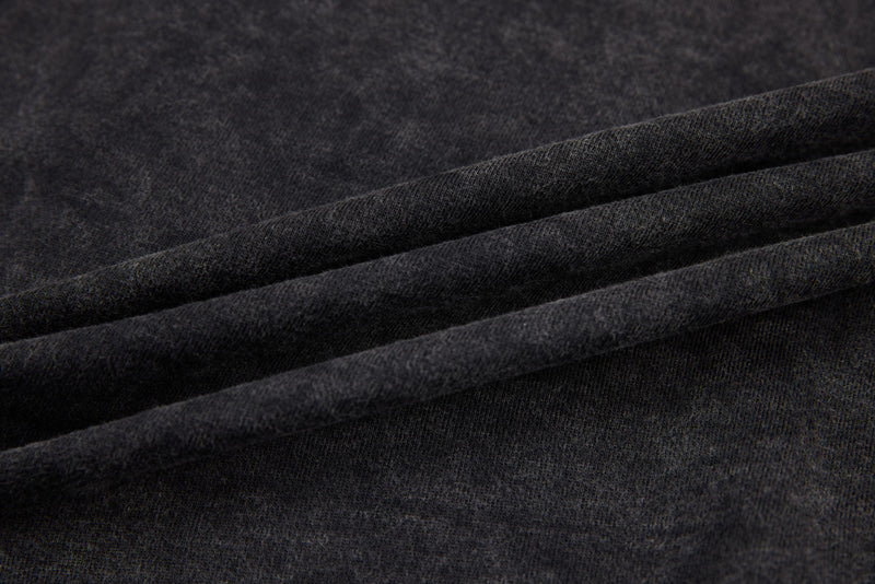 Close-up of black washed tee fabric folds showing soft faded texture