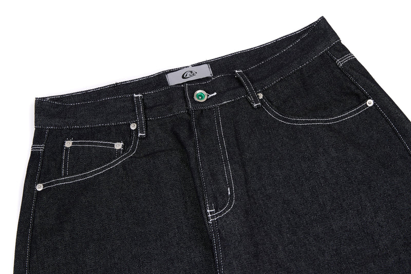 Close-up of black jeans waistband with button closure, belt loops, and front pockets