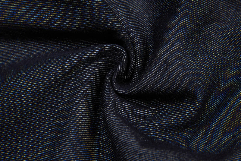 Close-up of black denim fabric gathered into soft folds