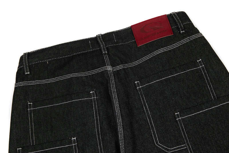 Back waistband of black denim pants with red Questionmark patch and white topstitching