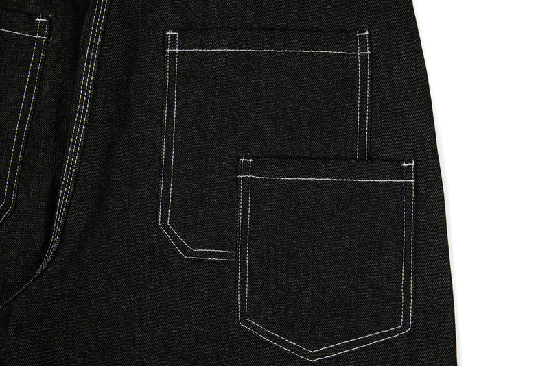 Black denim back pocket area with panel stitching and a large patch pocket