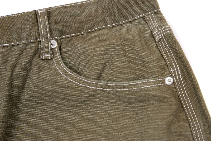 Close-up of olive denim pants front right pocket with contrast topstitching