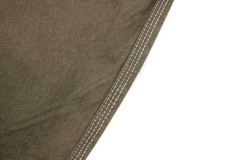 Close-up of olive denim pants side seam and contrast stitching on olive fabric
