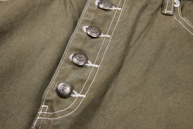 Close-up of olive denim pants button fly with contrast stitching and metal buttons