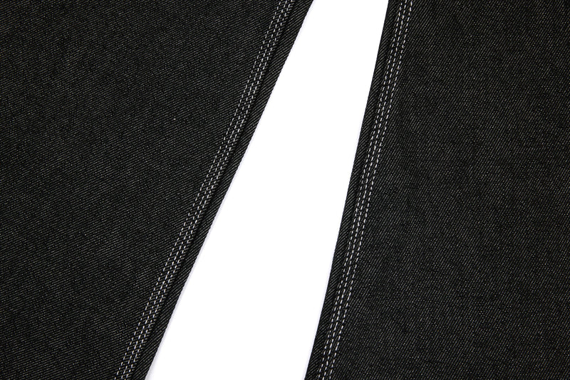 Close-up of black denim barrel leg shape with wide leg opening and side seams