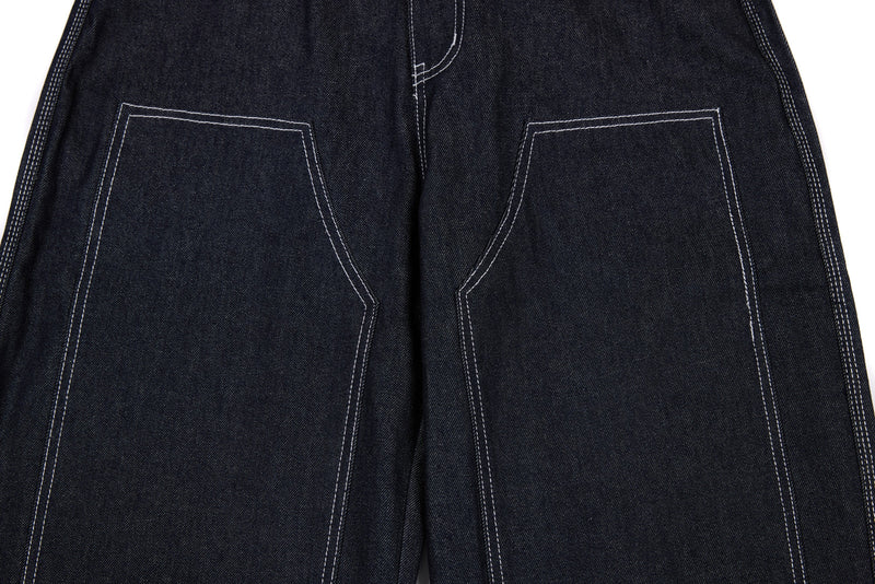 Back view of dark denim pants showing large stitched patch pockets