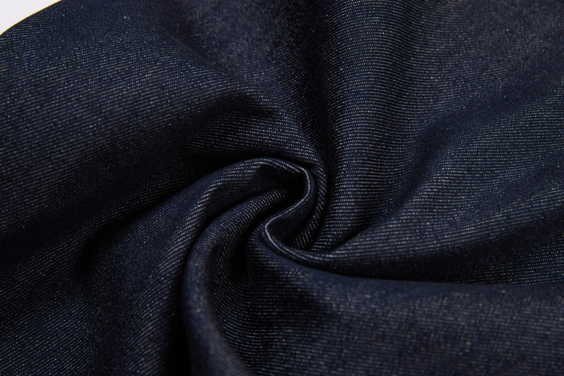 Close-up of folded dark denim fabric with soft texture and sheen