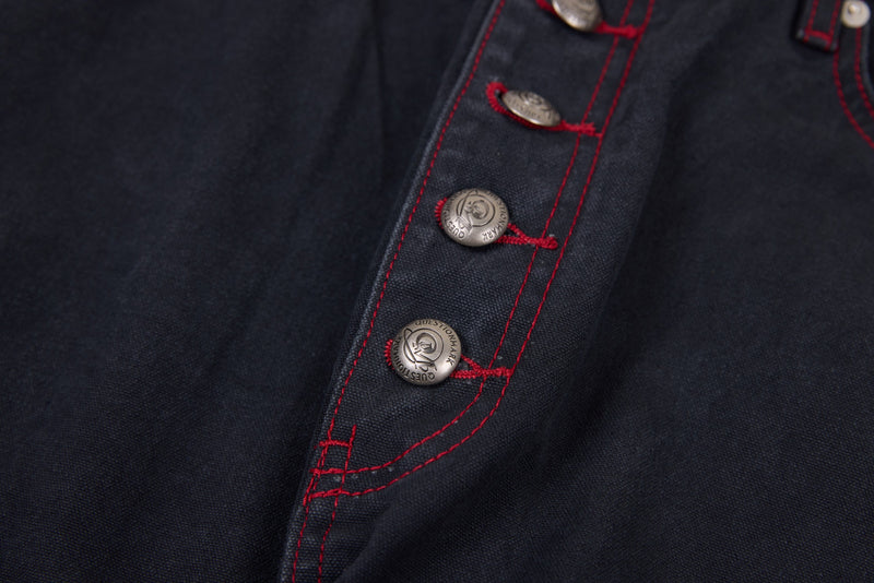 Close-up of button fly and red contrast stitching on dark denim pants