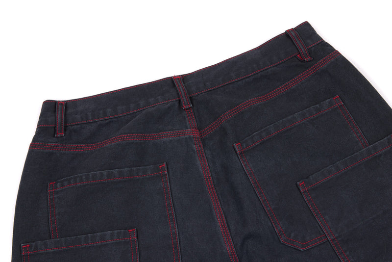 Back waistband and pockets of dark denim pants with red contrast stitching