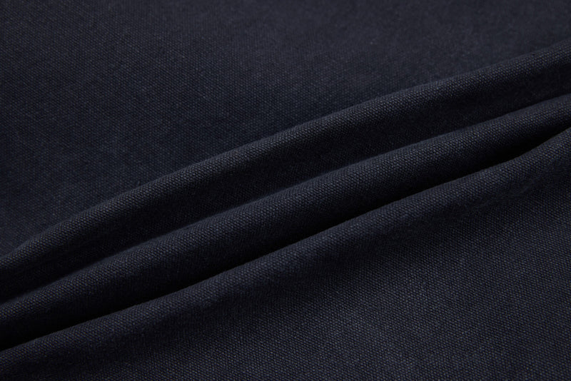Dark denim fabric close-up with soft folds and visible weave texture