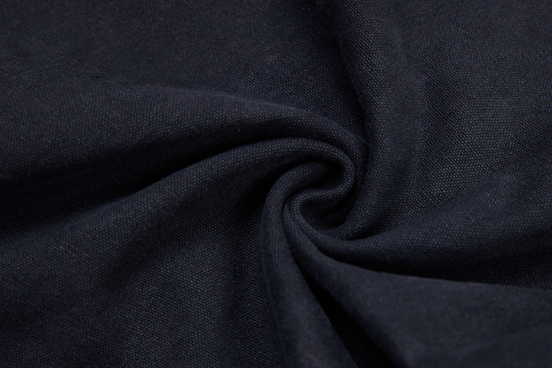 Dark denim fabric close-up with folded texture and fine weave