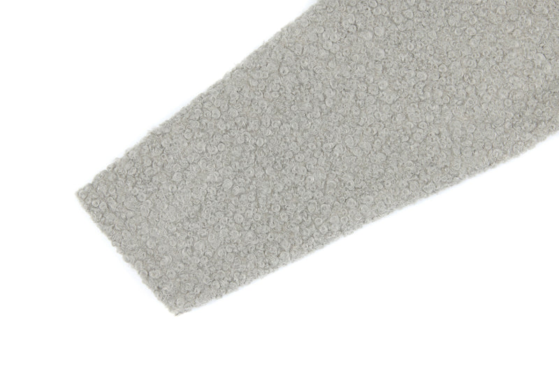 Close-up of light gray fleece sleeve with curly textured fabric