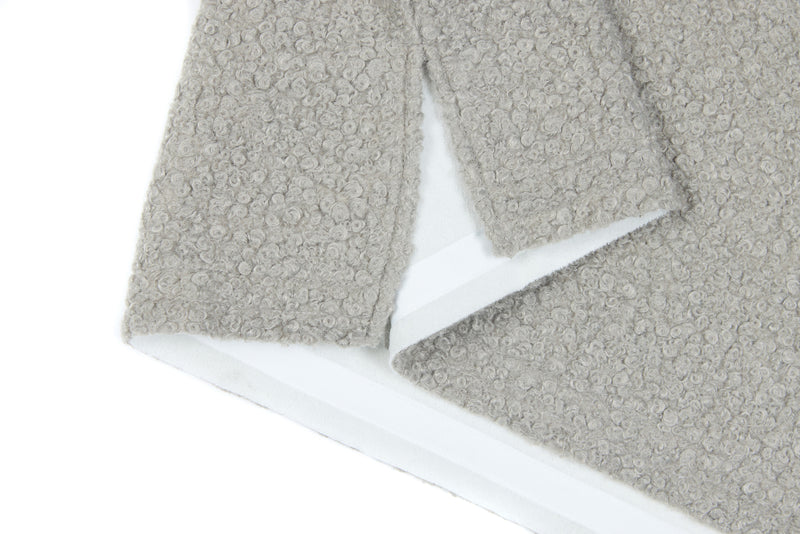 Close-up of light gray sweatshirt hem and side seam with white lining visible