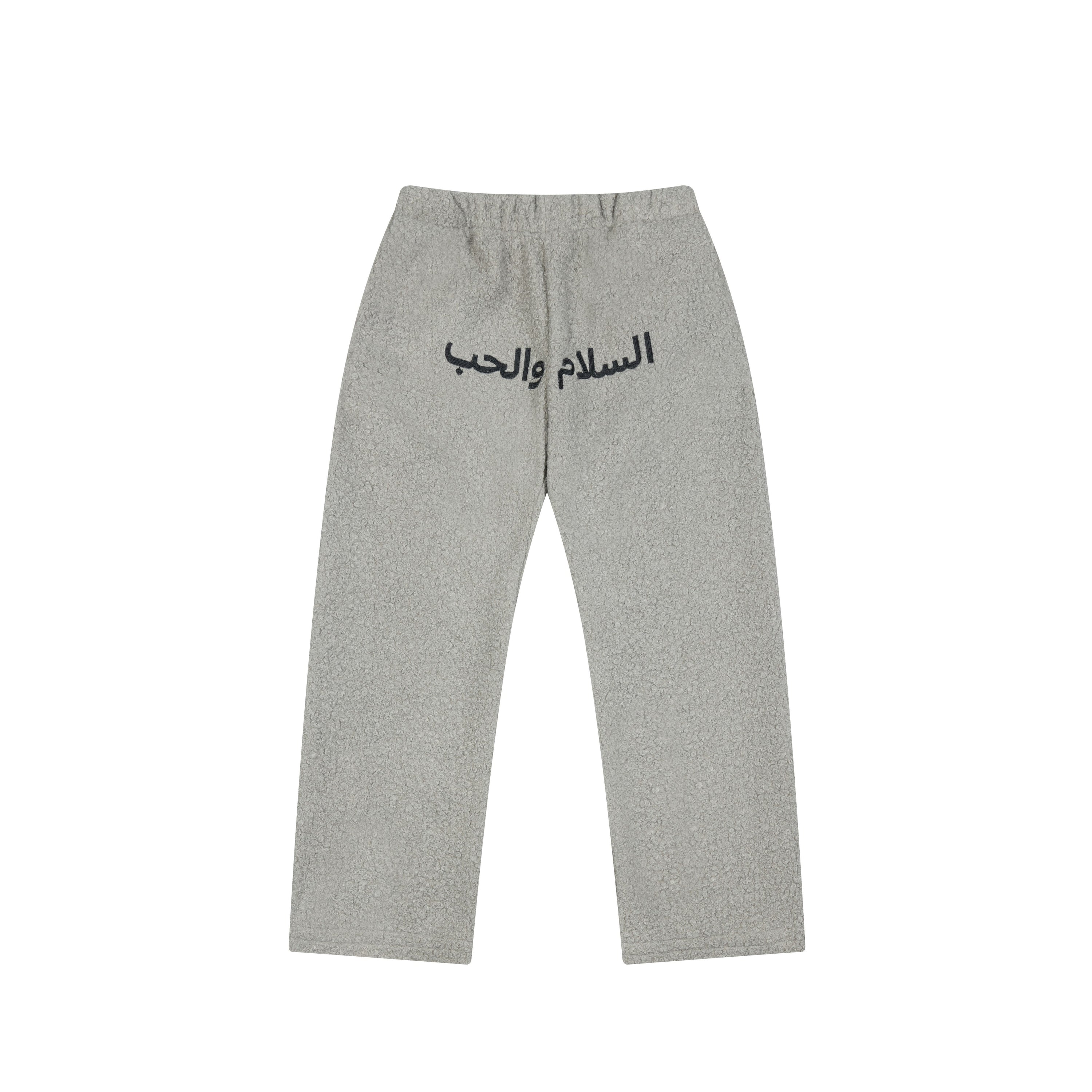 Grey textured fleece sweatpants with bold navy Arabic script print across the front and elastic waistband